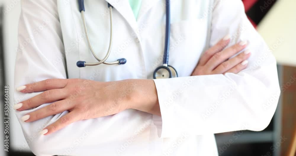 Cropped view of female therapist in white coat standing and posing with folded arms Cropped view of female therapist in white coat standing and posing with folded arms