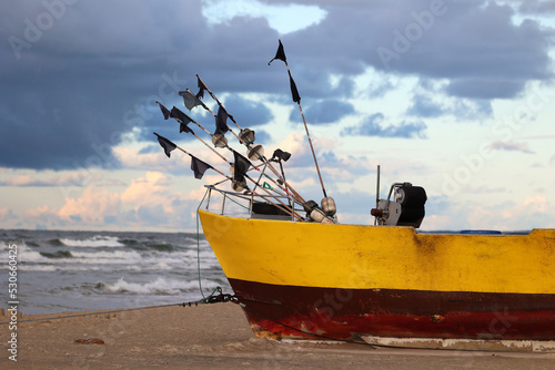 Żółty statek na plaży podczas zachodu słońca.  photo