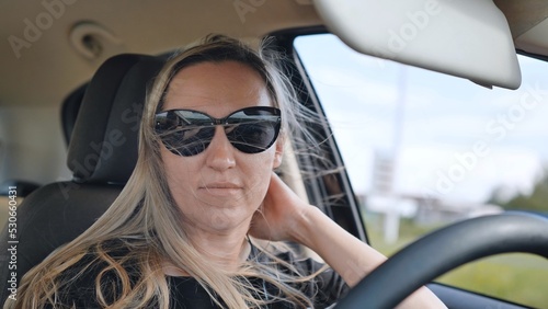 A young woman in a good mood behind the wheel of a car. © Довидович Михаил
