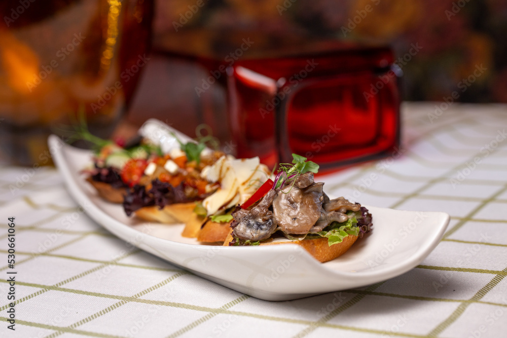 assorted bruschetta on a white plate on the table assorted bruschetta on a white plate on the table
