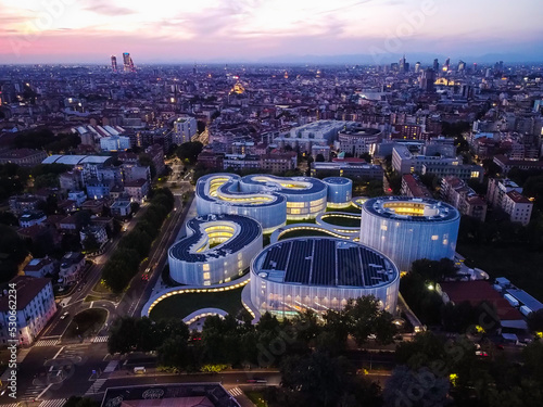 Aerial view of solar panels on the roof. The new campus of the SDA Bocconi School of Management is a modern building with classrooms. Colorful sky at sunset. Ecological energy. Milan Italy 09:2022