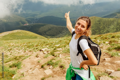 Fotografie Happy hiker pointing into distance of Carpathian mountains surrounded with clouds
