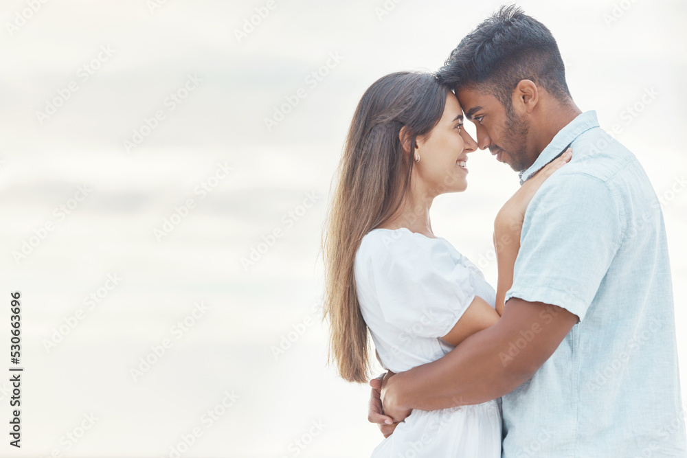 Date, love and couple at the beach hug, look in eyes and bonding together for anniversary, engagement or valentines day with mock up or copy space. Happy, intimate woman or people at outdoor vacation