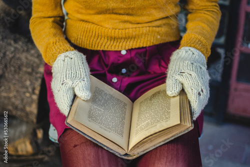 manos de mujer en invierno leyendo un libro