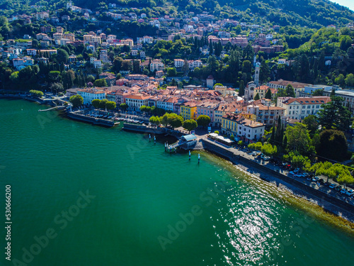 Aerial view of Lake Como. city ​​center. A local ferry arrives in the city. Bell tower. Tourism and romance. Mountains around the lake. Red roofs. Green Planet. Sailing yacht. Italy, Bellano, 10.2022 © VILTVART