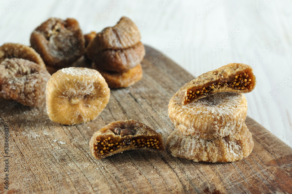 Close-up of dried figs on a wooden board. natural light, selective focus Close-up of dried figs on a wooden board. natural light, selective focus