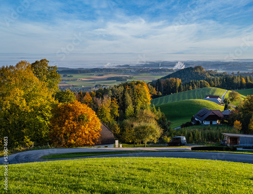 Peaceful autumn sunny morning rural view from Gmundnerberg with misty countryside in far, Austria.