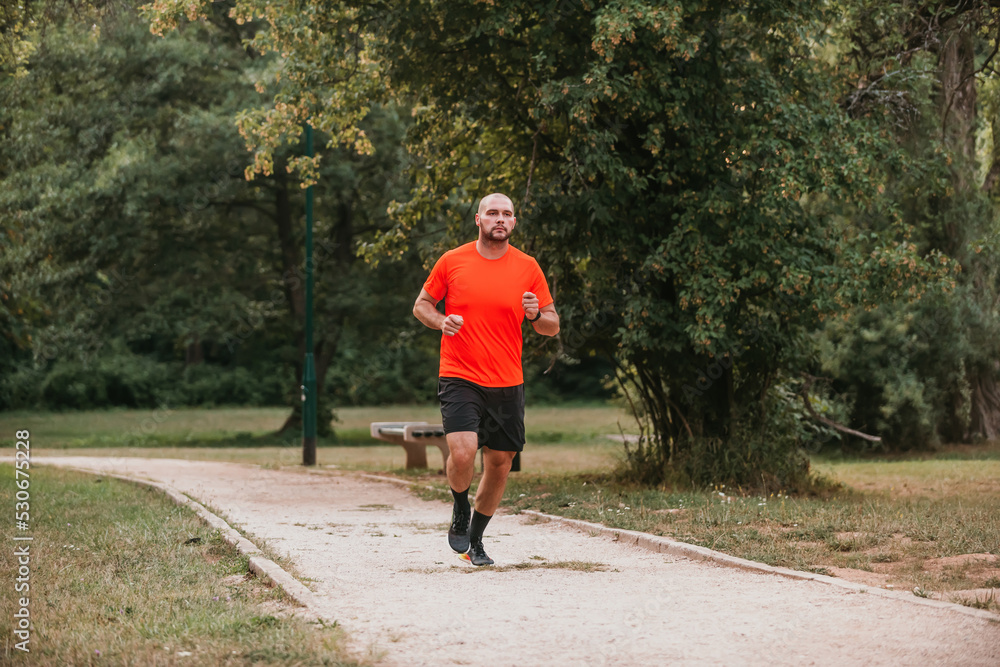 Fototapeta premium Athletic young man running in nature. Healthy lifestyle