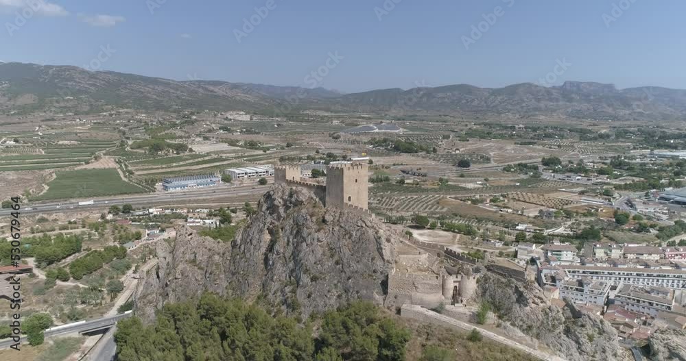 Vista latera con dron de fortaleza medieval sobre pueblo sin etalonar Vista latera con dron de fortaleza medieval sobre pueblo sin etalonar