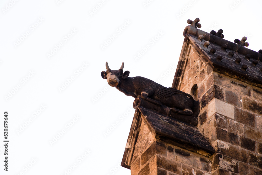 A statue of a bull in a facade of a church