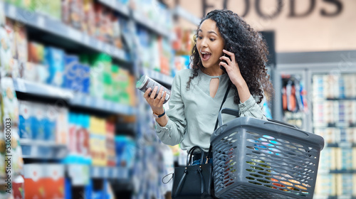 Supermarket, grocery shopping and surprise of a black woman on a phone call at a retail store. Wow, happy and omg facial expression of a customer hearing deal, price sale on stock and discount food photo