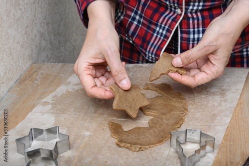 Female hands hold gingerbread dough in the form of a star and a Christmas tree