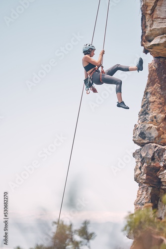 Woman climbing mountain with rope, outdoor nature activity and fitness exercise. Cliff rock climb, mountaineering adventure and action danger risk. Safety gear, peaceful earth and freedom motivation