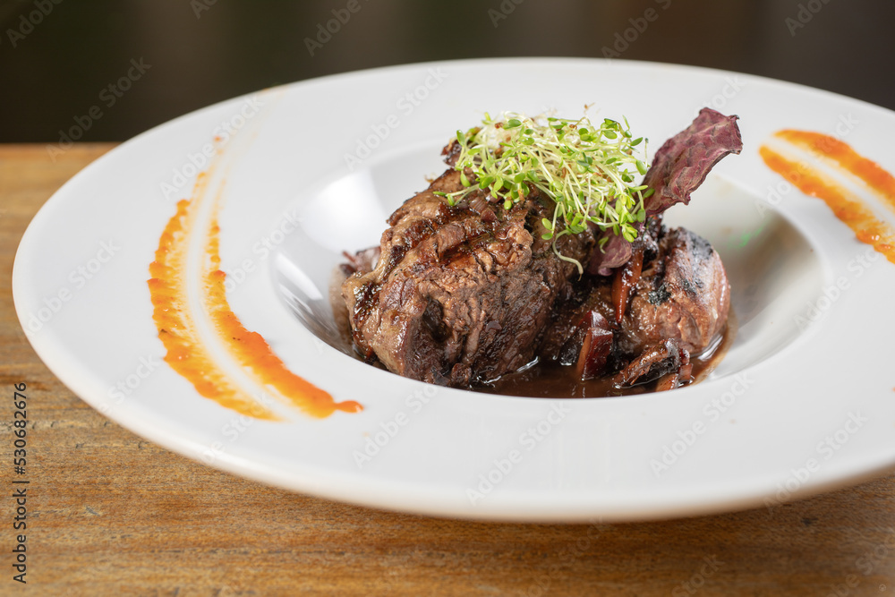 Different cuts of meat, chicken and pork on a white plate on a light wooden background
Different cuts of meat, chicken and pork on a white plate on a light wooden background
