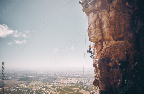 Wallpaper Mural Mountain, rock climbing and sport with a sports woman and climber abseiling on a mountainside outdoor in nature