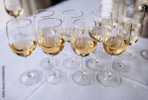 A lot, a row of glass glasses with champagne stands on the table. Photography, party.