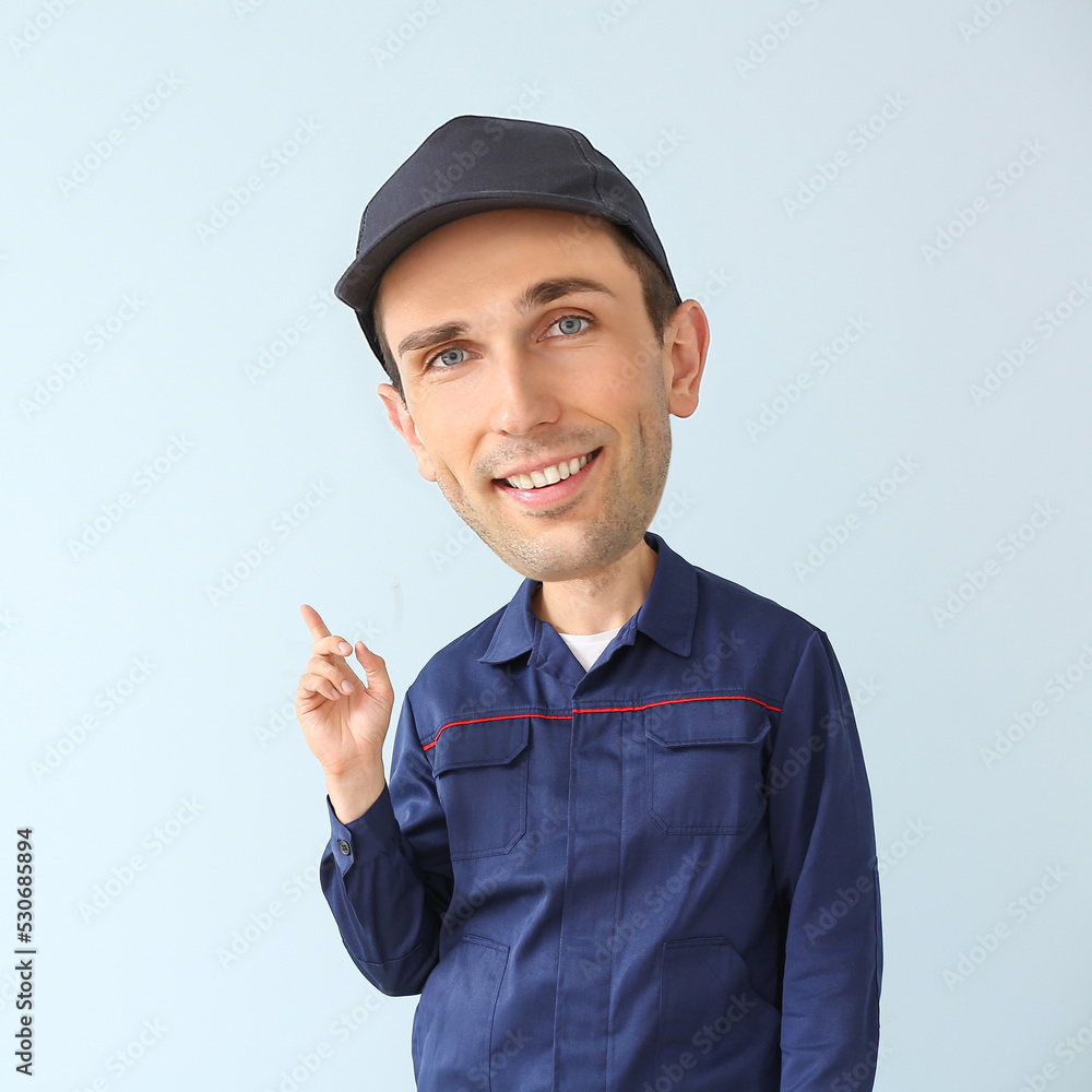Funny car mechanic with big head pointing at something on light background Funny car mechanic with big head pointing at something on light background