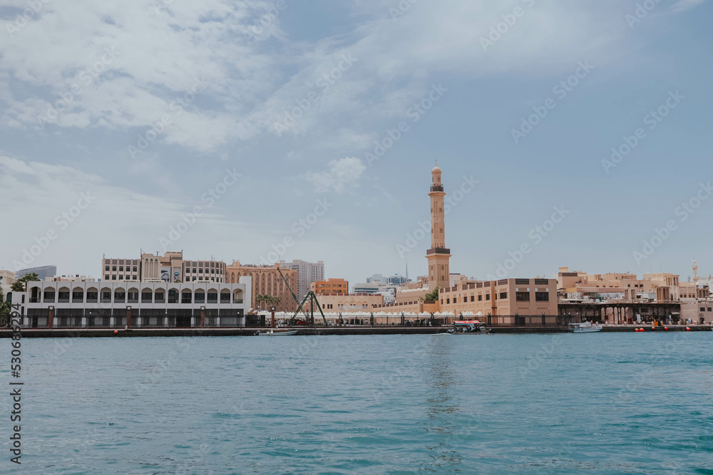 View of Dubai Creek channel with traditional Abra boats and piers. Famous tourist destination in UAE, United Arab Emirates. Historic Old arab town. Deira Old Souk. Artificial river length of 3 km
