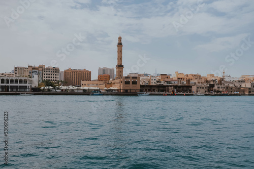 View of Dubai Creek channel with traditional Abra boats and piers. Famous tourist destination in UAE, United Arab Emirates. Historic Old arab town. Deira Old Souk. Artificial river length of 3 km