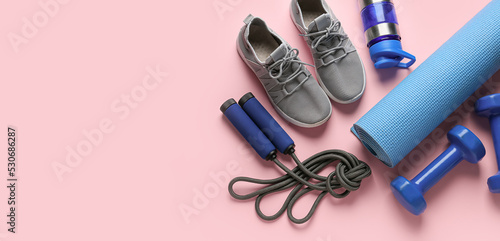 Shoes and sports equipment on pink background with space for text