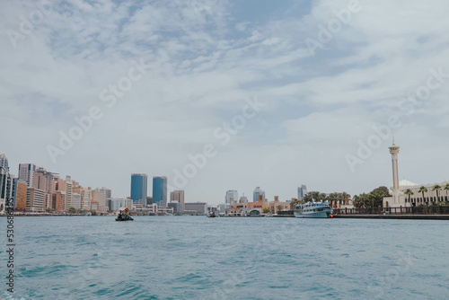 View of Dubai Creek channel with traditional Abra boats and piers. Famous tourist destination in UAE  United Arab Emirates. Historic Old arab town. Deira Old Souk. Artificial river length of 3 km