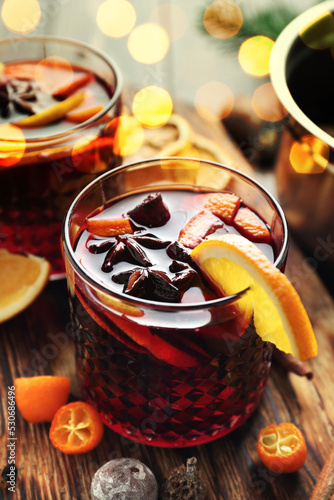 Glass of delicious mulled wine on wooden table, closeup