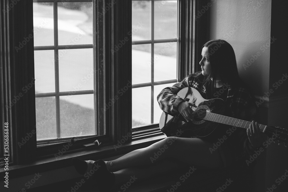 female songwriter, musician playing the guitar.