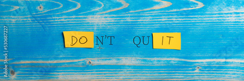 Wide view image of a Dont quit, Do it sign spelled on yellow papers