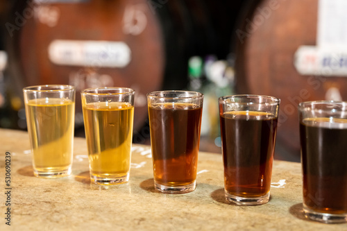 Tasting of different sweet wines from wooden barrels on old bodega in central part of Malaga, Andalusia, Spain