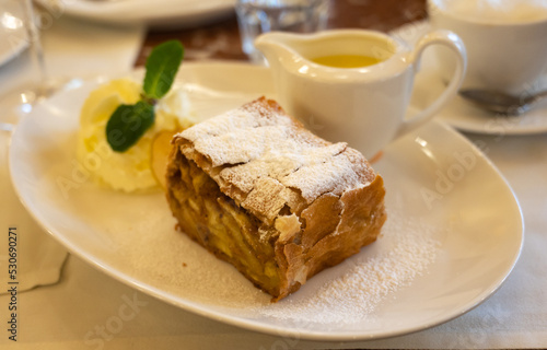 Canvas Print Austrian sweet dessert, portion of apple strudel with whippen cream and hot vani