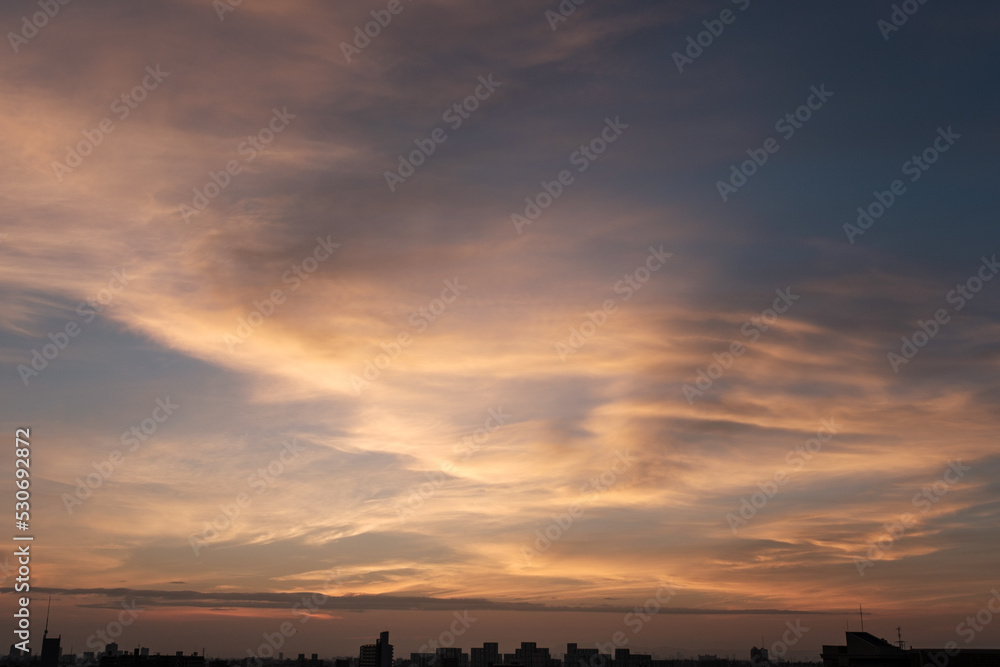 都市の夜明け。東の空が明るくなり雲がまだ昇る前の太陽に照らせら美しいグラデーションを見せる。神戸市内から大阪方面を臨む。 都市の夜明け。東の空が明るくなり雲がまだ昇る前の太陽に照らせら美しいグラデーションを見せる。神戸市内から大阪方面を臨む。