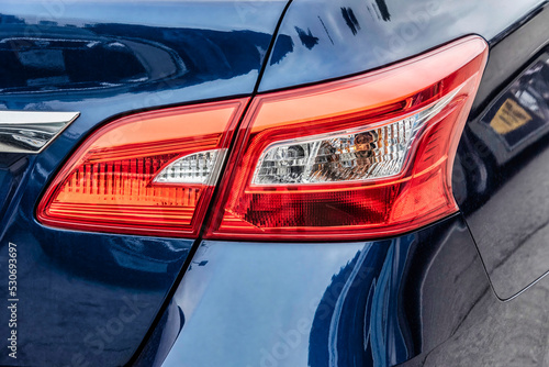 Closeup of a headlight on a dark blue car. © Luis G. Vergara