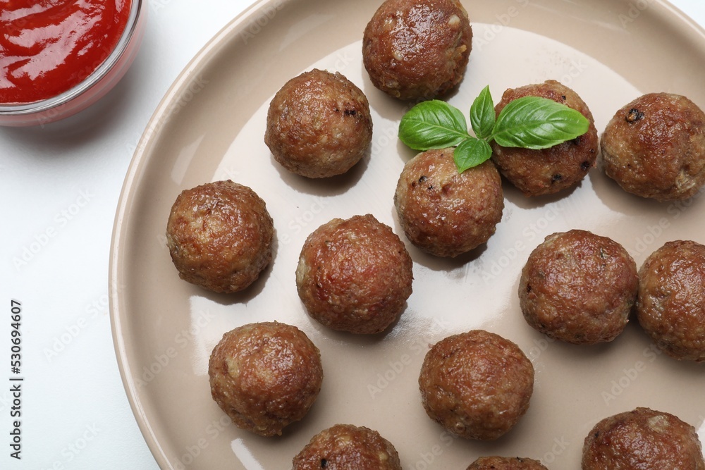 Tasty cooked meatballs with basil on white table, flat lay Tasty cooked meatballs with basil on white table, flat lay