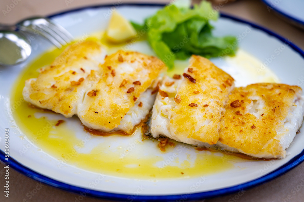 Grilled fillet of white codfish served in fish restaurant in San Sebastian, Basque Country, Spain Grilled fillet of white codfish served in fish restaurant in San Sebastian, Basque Country, Spain