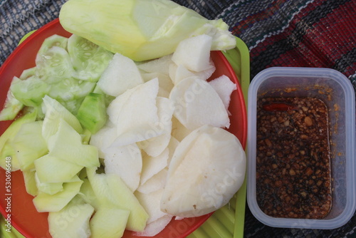 rujak manis is a kind of salad. Made from fresh fruits with sweet and spicy sauce. The fruits used include: young mango, yam, salak, almost ripe papaya, kedondong, guava, cucumber, star fruit, etc. photo