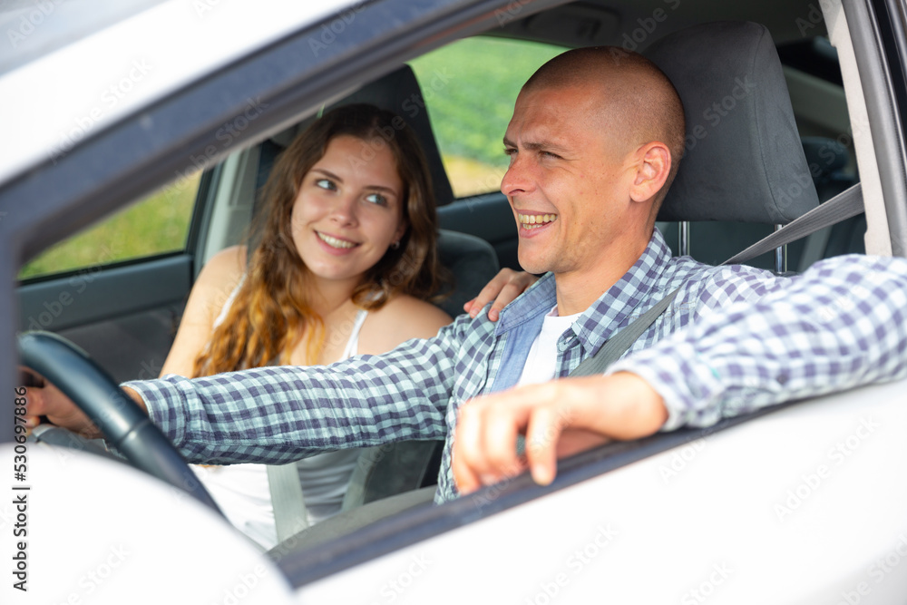 Positive woman and man talking in car during common trip