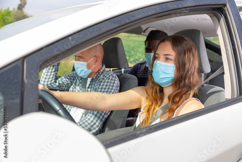Positive woman and man in protective mask in car during common trip © JackF