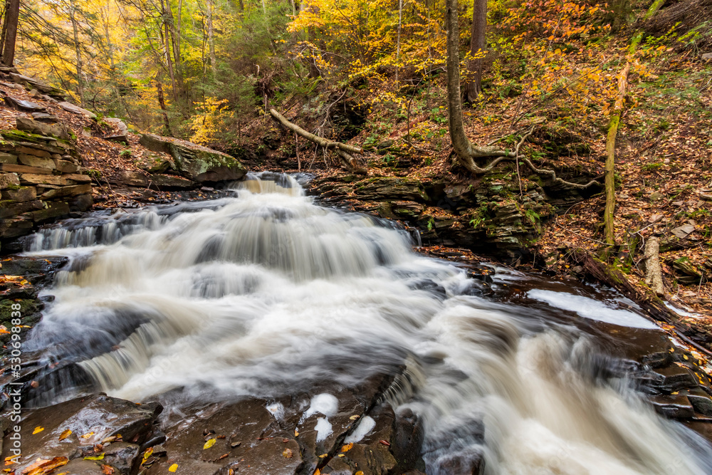 tranquil landscape of silky cascading water  against vibrant autumn forest background in Pennsylvania 