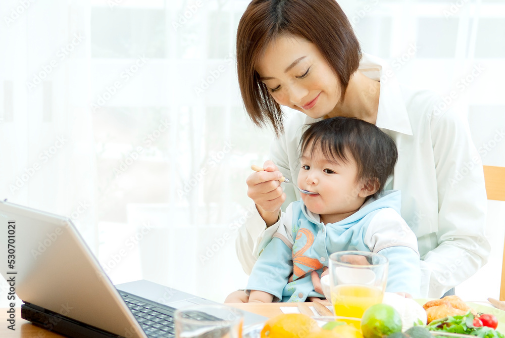 赤ちゃんにご飯を食べさせる母親 赤ちゃんにご飯を食べさせる母親