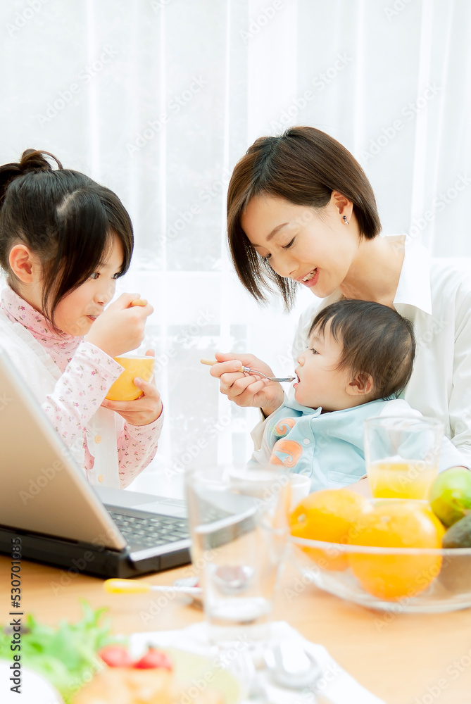 子供と朝食を食べる母親