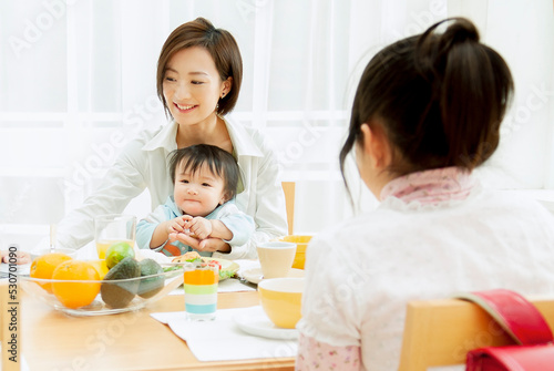 子供と朝食を食べる母親