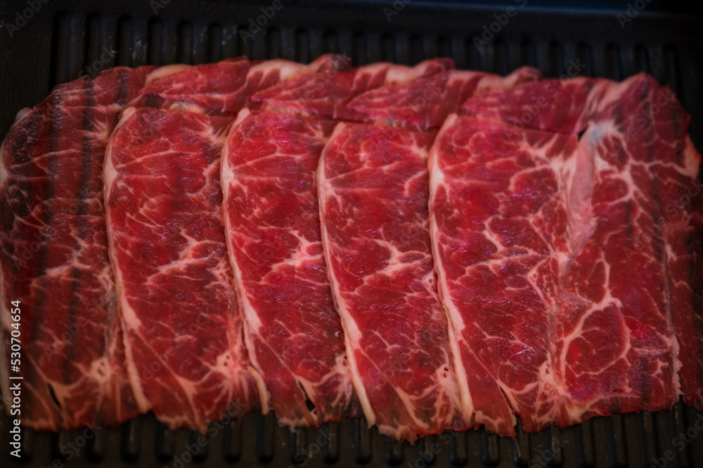 Thinly sliced of raw beef on tray prepare for customer cook. Japanese
