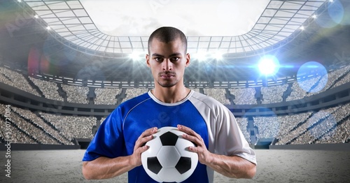 Composition of male football player holding football over sports stadium © vectorfusionart