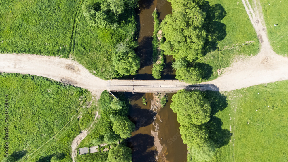 car bridge, bridge over a small flat river view from a drone