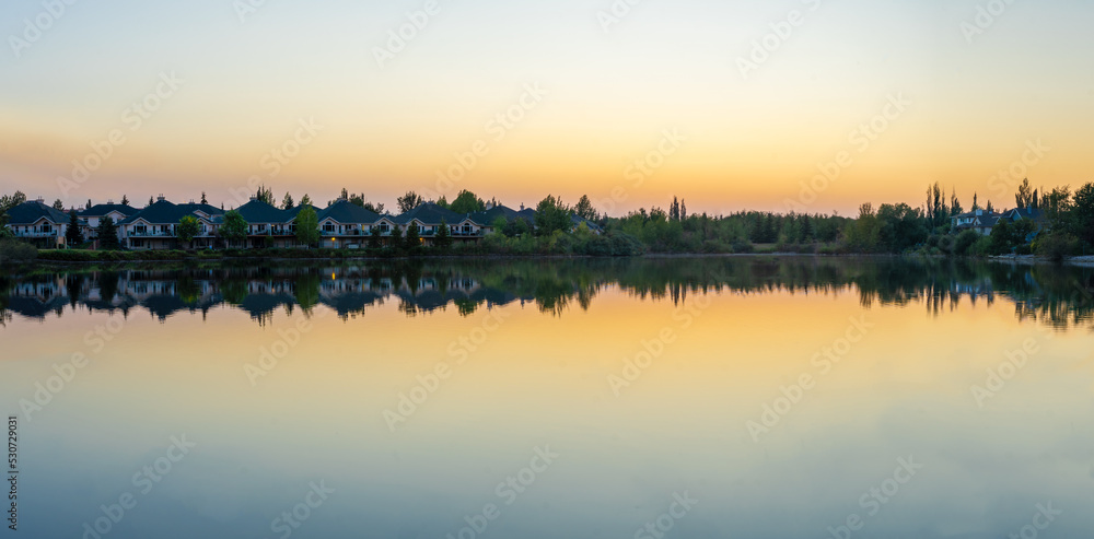 suburban houses beside a lake at sunset
