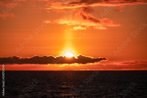Watching the sunset at the port of Puerto de la Cruz  Tenerife  Canary Islands  Spain  Europe. View of the horizon of Atlantic Ocean. The sun is reflecting in the calm sea. Vibrant clouds in the sky