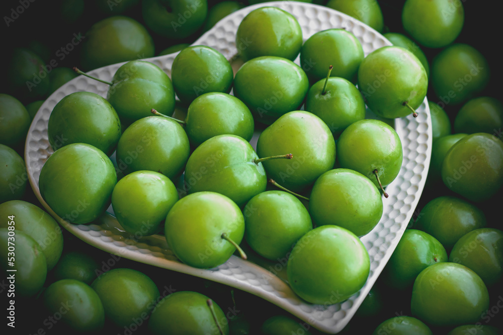 green plums on a white plate
