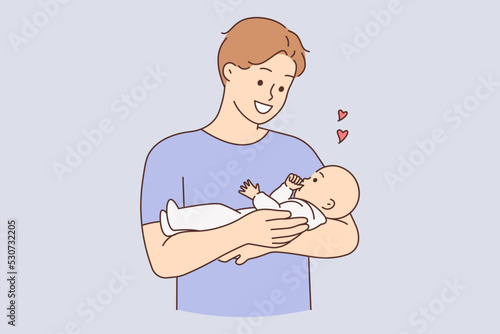 Happy father holding baby in arms 