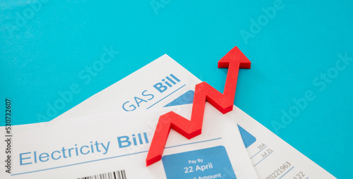 Electricity and gas bills and red rising up arrow. Heating and energy cost increase photo