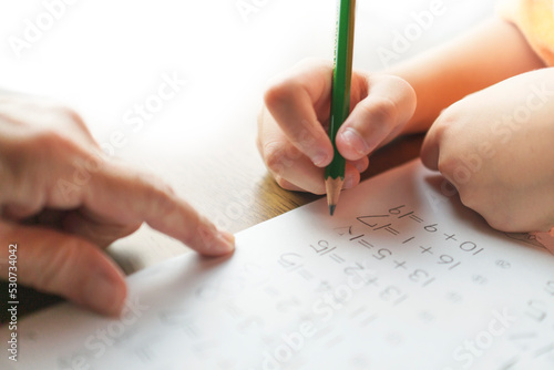 おばあちゃんと一緒に宿題の見直しをする男の子。足し算、計算ミス、小学１年生、算数、たしかめ算